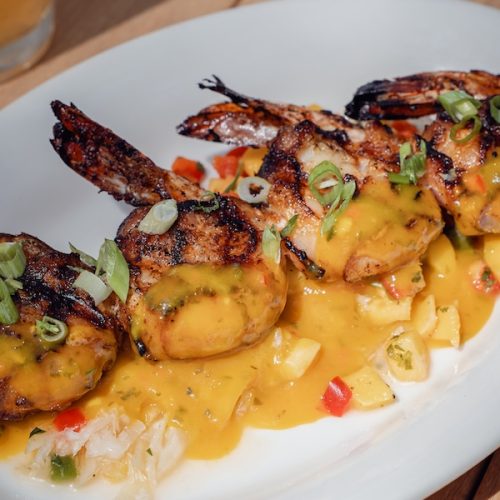 Grilled bacon-wrapped voodoo shrimp with papaya vinaigrette served over rice