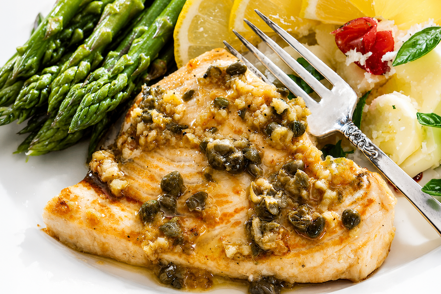 Swordfish with lemon-caper sauce served with asparagus