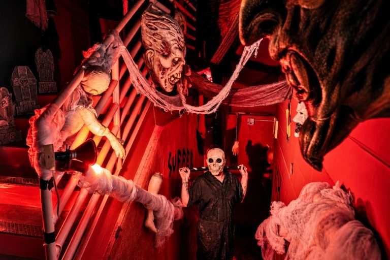 Costumed horror characters in a red-lit haunted attraction