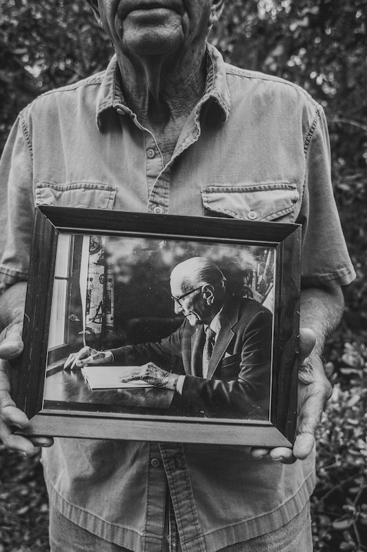 Thomas Heyward McTeer holding a framed portrait of his father J.E. McTeer