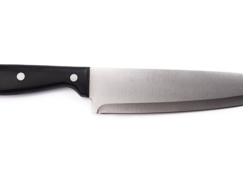 Chef’s knife beside a penny illustrating a family knife-gifting superstition