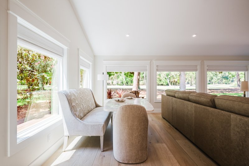 Sunlit seating nook with upholstered chairs and large windows