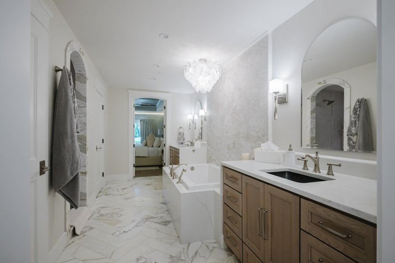 Bright bathroom with freestanding tub, double vanity and neutral stone finishes