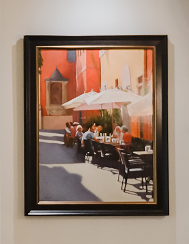 Framed painting of an Italian street scene displayed in the home