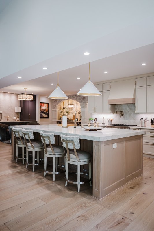 Renovated Sea Pines kitchen with large stone island, bar seating and white pendant lights
