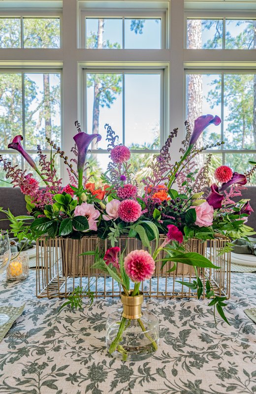 Pink and purple dahlias, purple calla lilies and colorful flowers rising above an open gold floral framework