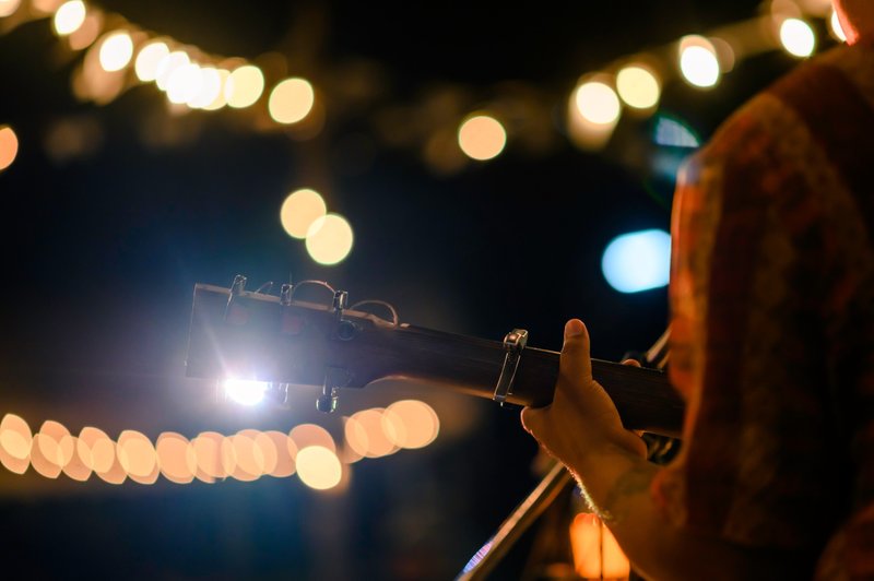 Guitarist playing at an outdoor evening gathering
