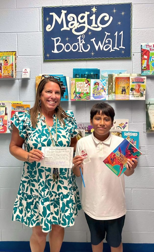 Principal Michelle Brockway with a student holding a certificate and book at Hilton Head Island Elementary School