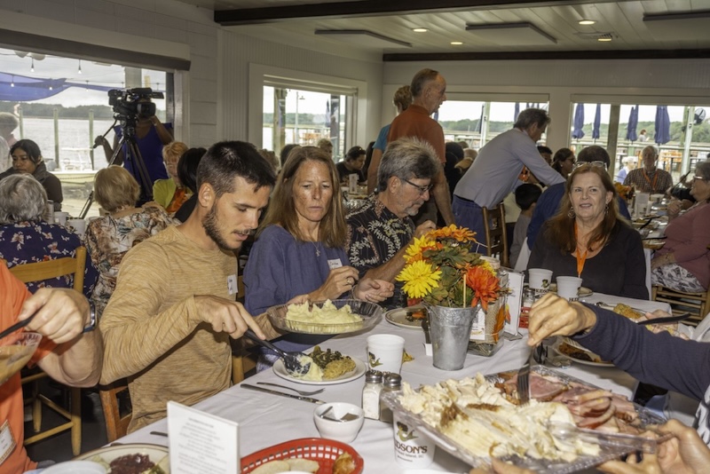 Community members share a meal together around a restaurant table.