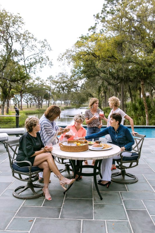 Guests seated around an outdoor table overlooking the water