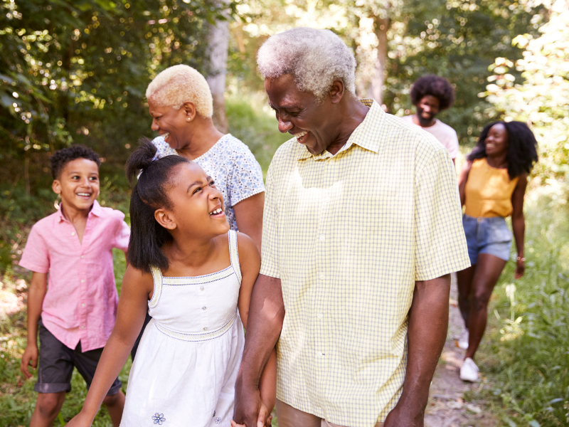 Elderly couple walking through woods with grandchildren