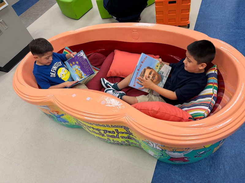 Two Hilton Head Island Elementary School students read together in a boat-shaped reading area