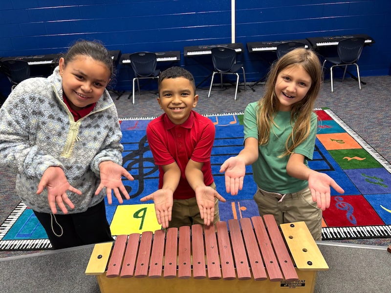 Three students use a xylophone during a hands-on math and music activity at the Creative Arts school