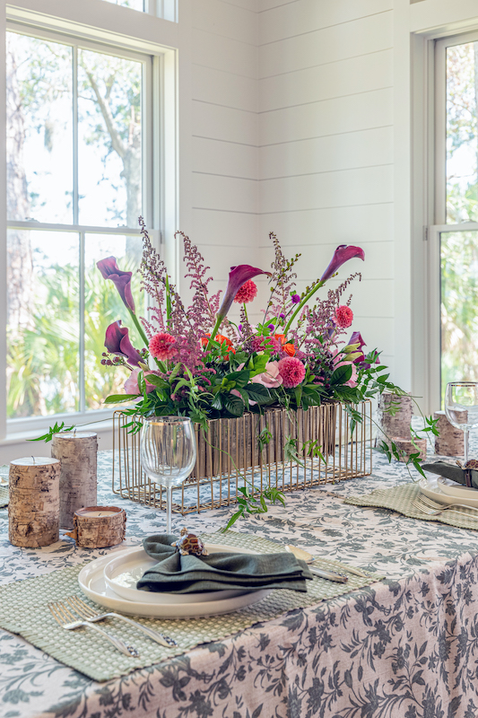 Pink and purple dahlias, purple calla lilies and colorful flowers rising above an open gold floral framework