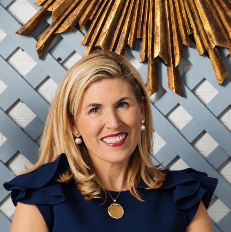 Portrait of interior designer Leslie May wearing a navy top and gold necklace