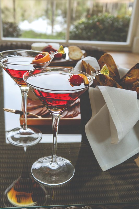 Two red cocktails served in stemmed glasses