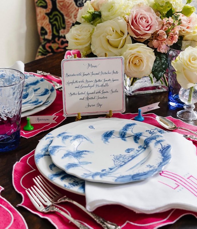 Blue-and-white china on a white monogrammed napkin with pink accents, flowers and a printed place card