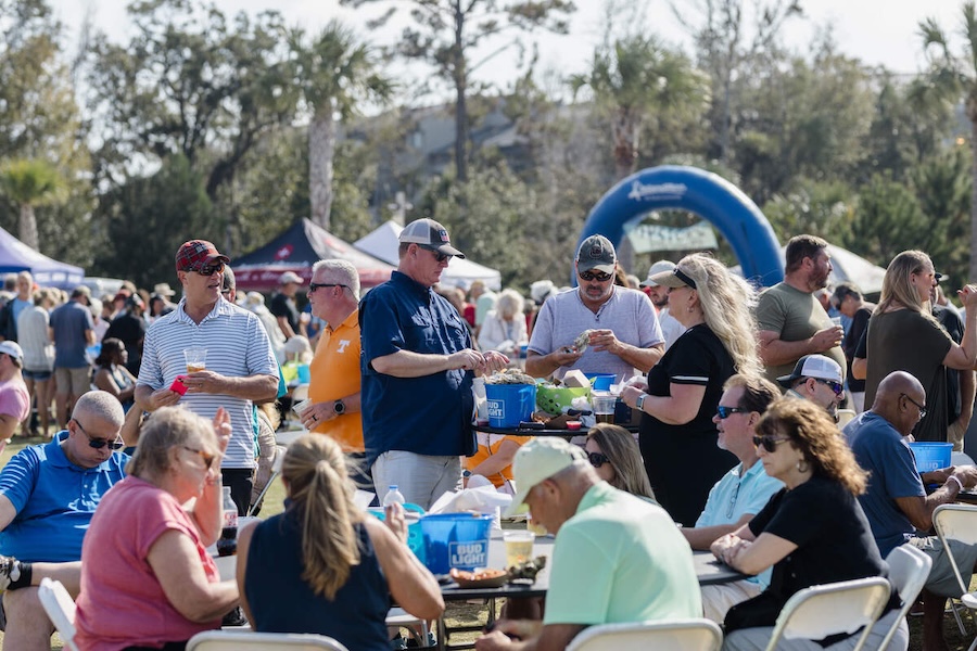 Festivalgoers gather around outdoor tables at the Hilton Head Island Oyster Festival.