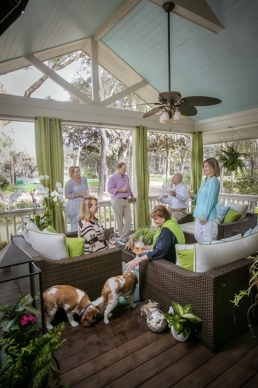 Guests relaxing on a screened porch overlooking Harbour Town Golf Links