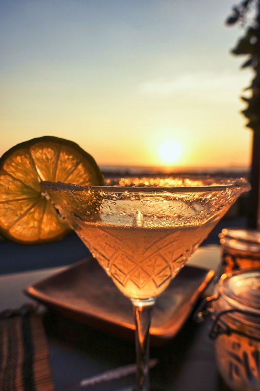 Cocktail glass photographed against a golden sunset